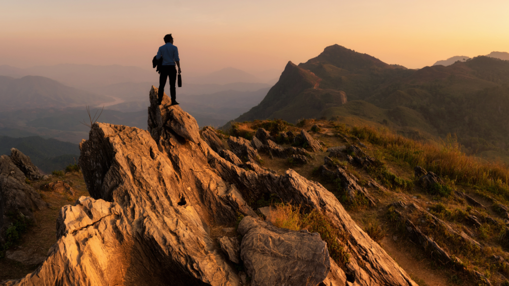 Man on top of a mountain looking forward to what the future holds. He's filled with hope, faith and determination to take on anything that comes his way.