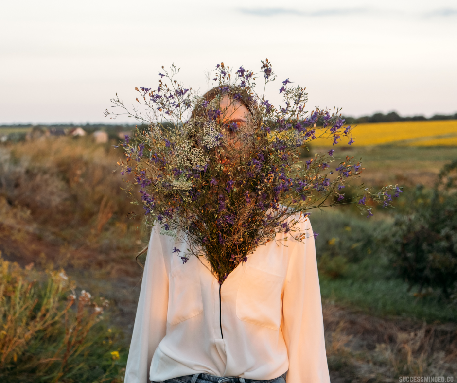 Steps to Cultivate Greater Self-Belief | Decorative Image of a woman hiding her face behind a flowering bush
